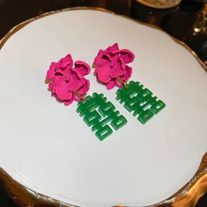 Vue détaillée de boucles d'oreilles fleurs magenta avec pendentif Double Bonheur vert