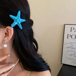 Detailed view of a blue acrylic starfish hair clip styled on elegant black wavy hair