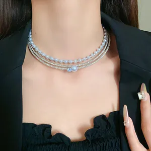 Detailed view of elegant multi-layer rhinestone choker featuring faux pearls and blue gem