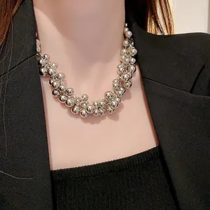 Fashionable silver cluster bead necklace detailed view on model wearing black suit.
