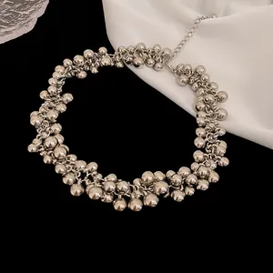 Close-up detail of silver clustered ball necklace with metallic individual design