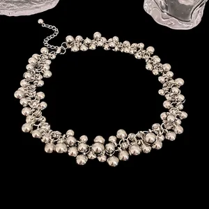 Detailed macro shot showing the intricate clustered silver metallic sphere necklace design