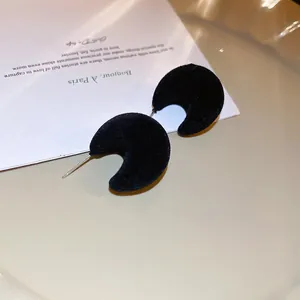 Détail de boucles d'oreilles en croissant de lune en velours noir sur carte