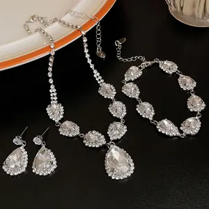 Nahaufnahme von Halskette, Armband und Ohrringen mit birnenförmigen Strasssteinen.
