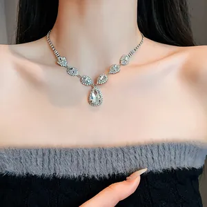 Detaillierte Nahaufnahme einer eleganten Strass-Halskette in Tropfenform am Hals eines Models