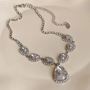 Detailansicht einer silbernen Vintage-Halskette mit funkelnden klaren Strass-Wassertropfen.