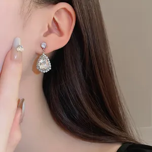 Nahaufnahme eleganter diamantbesetzter Tropfenohrringe an einem Modell im Vintage-Stil
