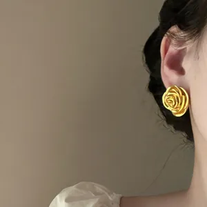 Elegante Nahaufnahme von Vintage Gold-Rosenohrsteckern, die am Ohr getragen werden