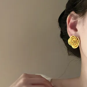 Eleganter goldener Vintage-Ohrstecker in Rosenform am Ohr des Models in der Detailansicht