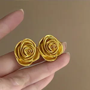 Nahaufnahme eleganter goldfarbener Rosen-Ohrstecker mit detaillierten Blütenblättern