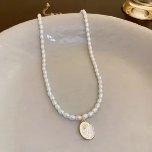 Elegante collana di perle francese con pendente ovale bianco e motivo rosa dorata.