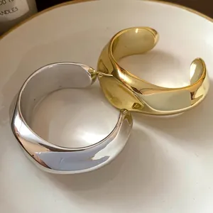 Brazalete abierto irregular plisado con acabados en oro y plata pulidos elegantes