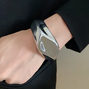 Brazalete abierto plateado brillante irregular con textura de metal líquido