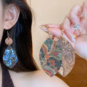 Detail view of vintage leaf-shaped printed dangle earrings featuring colorful floral patterns