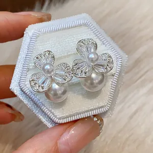 Close-up detail of French style flower pearl earrings with sparkling zircon petals