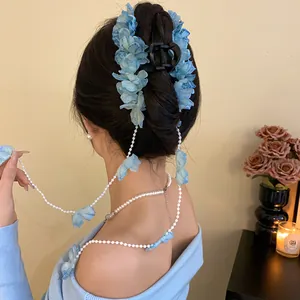 Vue arrière d'une femme portant une pince à cheveux fleur bleue avec glands en perle