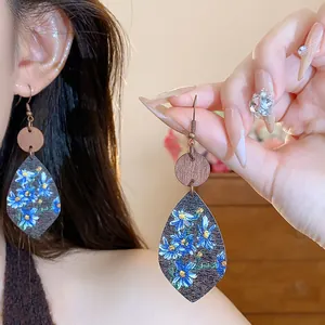 Detailed close-up of floral printed teardrop earrings featuring natural wooden accents