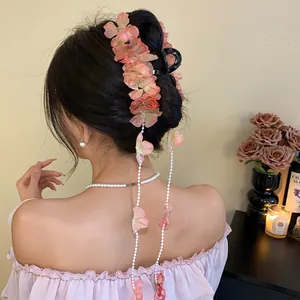 Détail de la pince à cheveux florale rose avec de longs glands élégants en perles de nacre