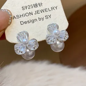Detailed macro view of elegant floral zircon earrings with pearls on an S925 silver needle