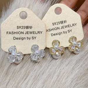 Close-up of zircon flower pearl earrings with S925 silver needles in gold and silver.