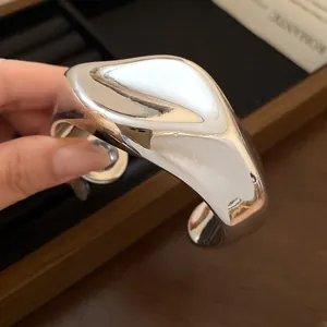 Primer plano detallado que muestra la textura plisada irregular de este brazalete plateado