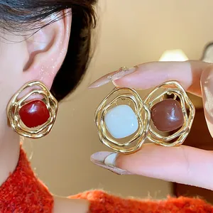 Detail of vintage irregular metal ear clips with colorful enamel dripping oil centers.