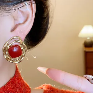 Close-up detail of vintage red drip oil irregular gold clip-on earrings for women