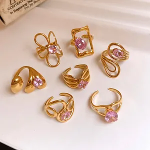 Detailed view of assorted gold-plated stainless steel rings with pink zircon stones