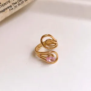 Detail view of a gold stainless steel open ring with a pink zircon in hollow floral design