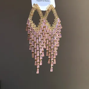 Close-up of pink zircon long tassel earrings with heavy rhinestone fringe