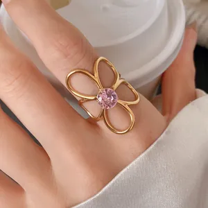 Close-up detail showing the texture of a gold hollow flower ring with a pink zircon stone