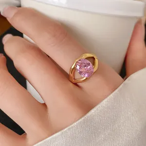 Close-up of a gold-plated open ring featuring a large oval pink zircon stone.