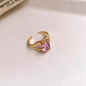 Detailed macro view of a gold stainless steel open ring with a round pink zircon