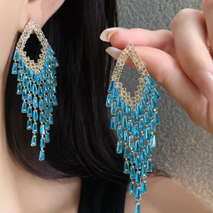 Close-up detail of luxurious geometric blue zircon tassel earrings in a gold-tone setting