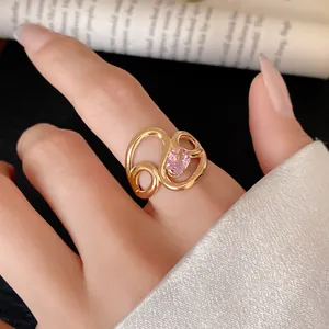 Macro view of a gold-plated stainless steel hollow ring with a pink zircon on a finger