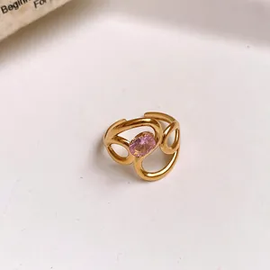 Detailed macro shot of a golden hollow flower open ring with a pink oval zircon stone