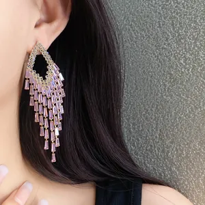 Exquisite detail view of pink zircon rhombus tassel earrings worn by a female model