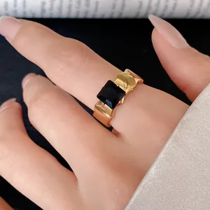 Close-up of a chunky gold-plated stainless steel ring with a square black zircon gemstone