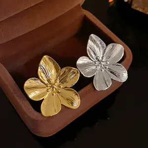 Vista detallada de anillos de flores bañados en oro y plata en un joyero de terciopelo.
