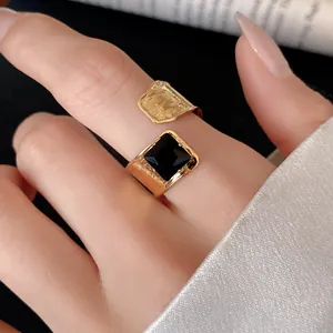 Detail shot of a gold-plated open ring featuring a bold square black zircon stone