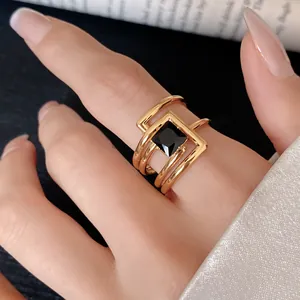 Detailed macro shot of geometric gold open ring with a square black zircon stone