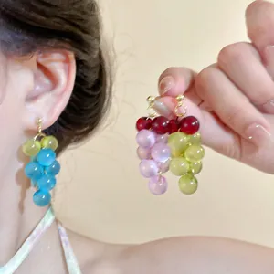 Primer plano de pendientes de cuentas en forma de uva con perlas de resina de colores