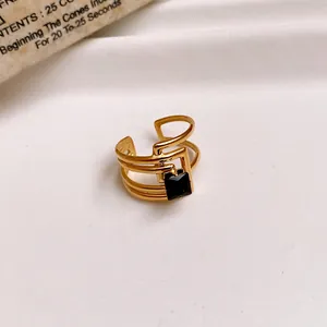 Close-up detail of a gold plated stainless steel open ring with a square black gemstone