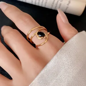 Elegant gold stainless steel open ring featuring a black zircon stone on a model's hand