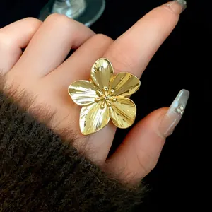 Primer plano de anillo ajustable con forma de flor bañada en oro y pétalos detallados