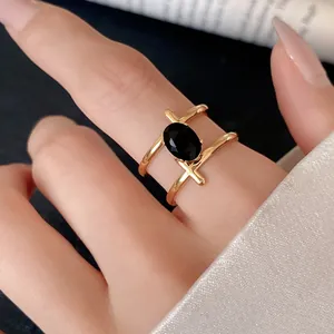 Detail shot of a gold double-band ring featuring a large oval black stone center