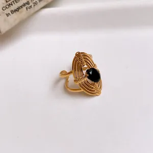 Detailed view of gold-plated hollow flower ring with a black oval zircon stone.