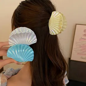 Iridescent shell-shaped hair claw clip for romantic beach style holiday hairstyles.