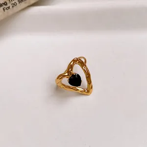 Detailed macro shot of a gold-toned hammered heart ring with a black zircon center.
