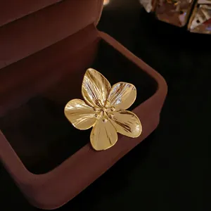 Detalle de primer plano de un anillo abierto de flor bañado en oro con pétalos texturizados